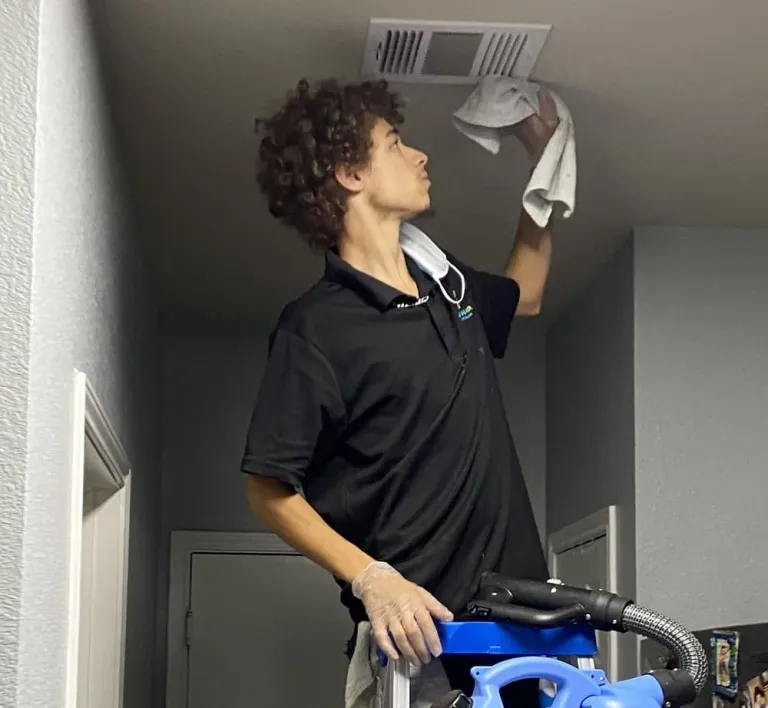 Supreme air care technician cleaning HVAC air duct vent