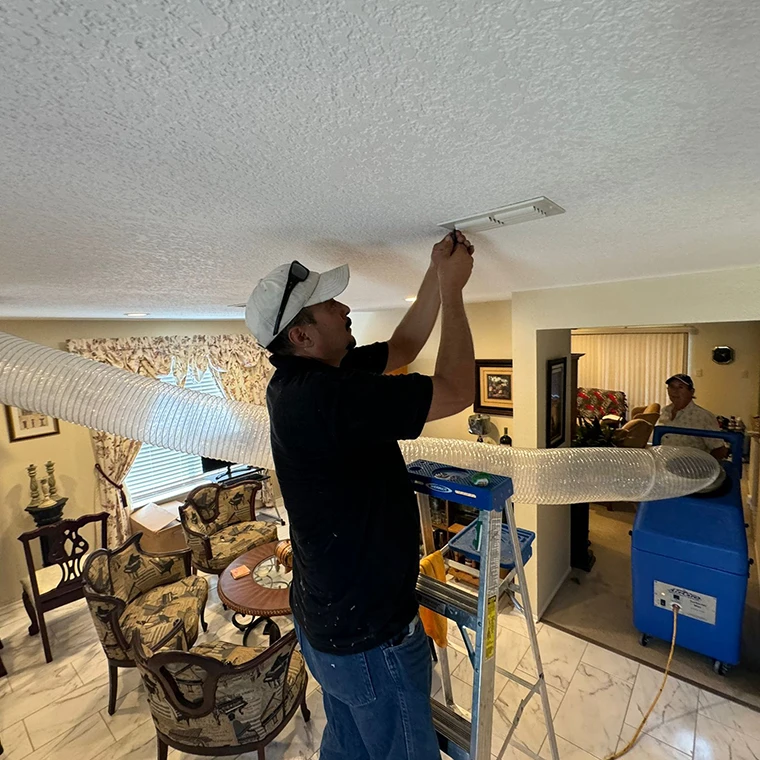 Technician removing dust and debris from a home's HVAC air duct system