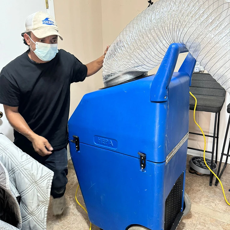 Supreme Air Care technician operating a negative air machine during residential air duct cleaning.
